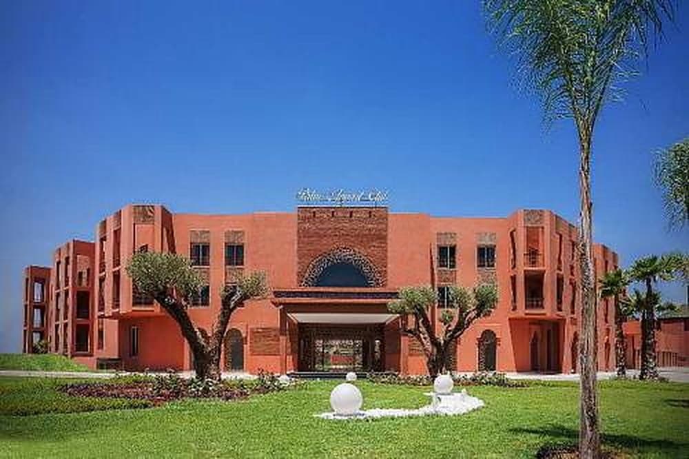 The hotel entrance with its Moroccan arch, lawns and palm trees