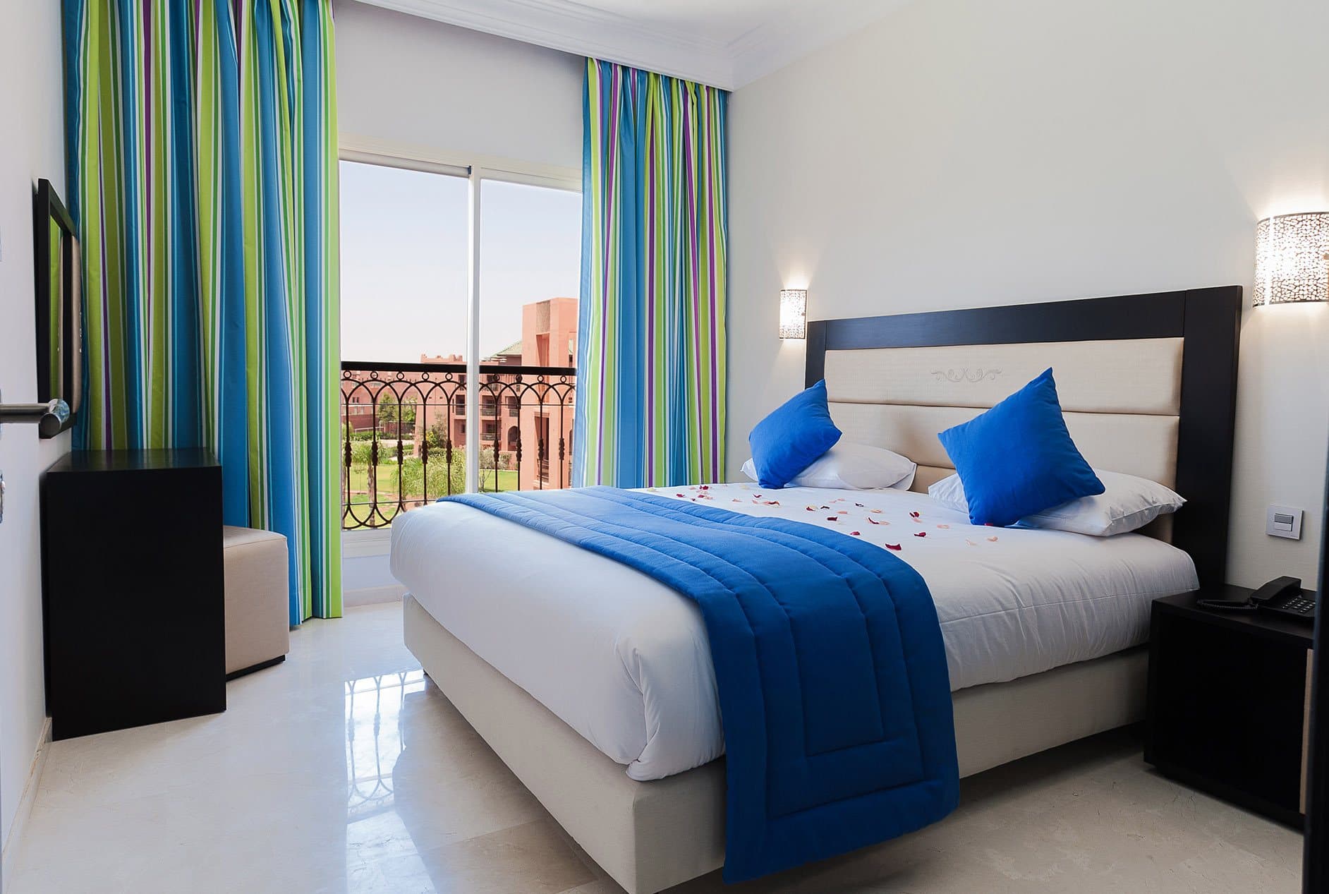 Junior Suite bedroom with blue accents and a balcony