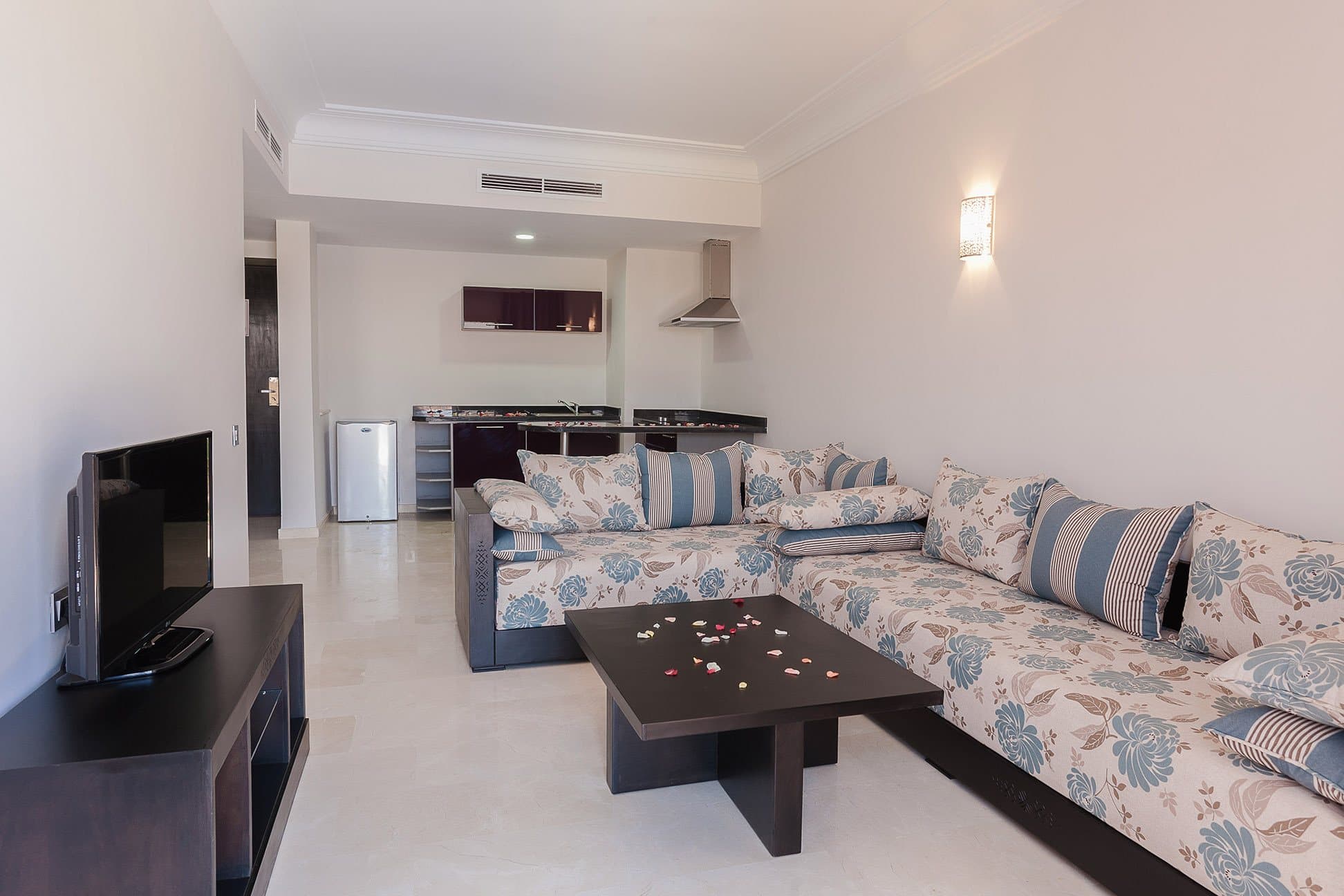 Junior Suite living room with an L-shaped sofa and kitchenette