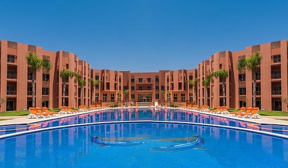 The pool and the hotel's red buildings