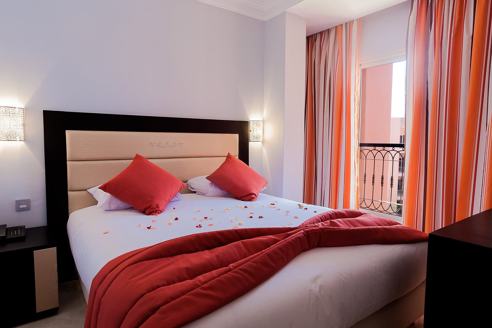 Double bedroom with red cushions and a balcony