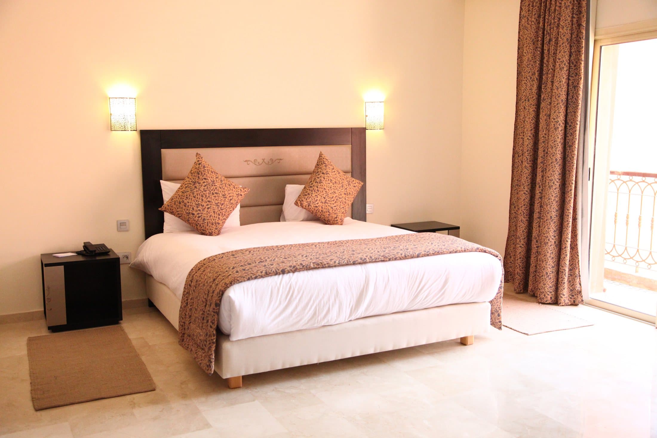 Standard Suite bedroom with a double bed and balcony doors